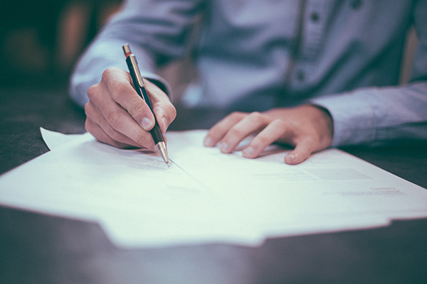 Photo of man writing with a pen